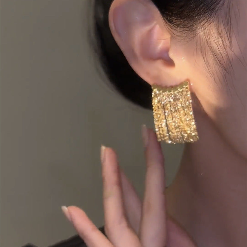 Lange Ohrringe mit geschwungenem Stab und Quaste